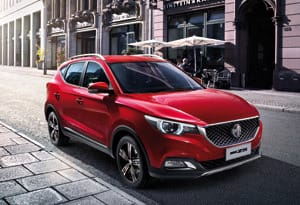 منظر أمامي جانبي لسيارة MG ZS حمراء متوقفة في شارع بالمدينة